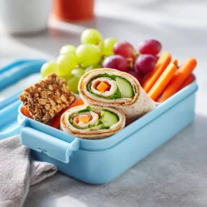Colorful school lunch box filled with kid-friendly foods.
