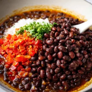 Bowl of vegan black bean chili garnished with avocado and cilantro